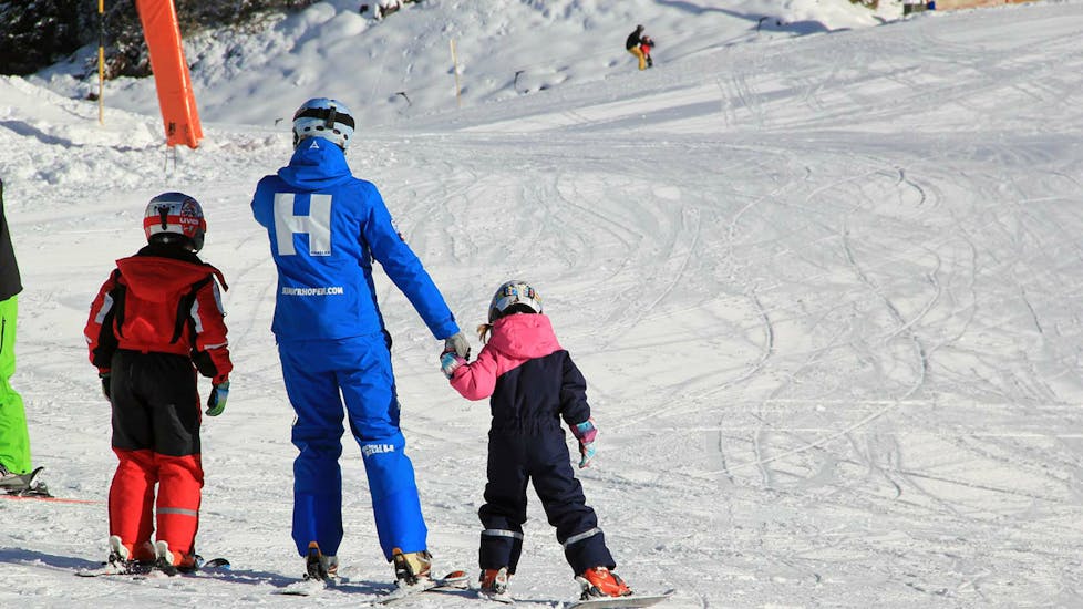 Eine Skilehrerin der Skischule Habeler Mayrhofen nimmt ein junges Mädchen während des Kinder-Skikurses "MAX6" (ab 6 J.) für Anfänger an der Hand.