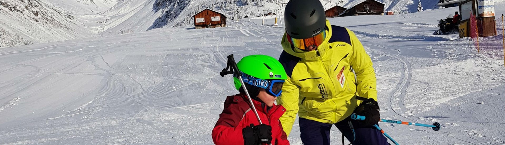 A ski instructor from Skischule Mountains is helping a participant of the Kids Ski Lessons "Las Lieurs" (4-17 years) - All-in-One.