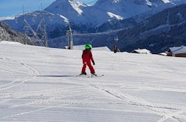 Ein junges Kind macht im Angebot Privater Kinder Skikurs (ab 3 Jahren) - All Levels der Skischule Monntains die ersten Schritte auf Skiern.