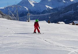 A young child is taking their first steps on skis during the Private Ski Lessons for Kids (from 3 years) - All Levels with Skischule Monntains.