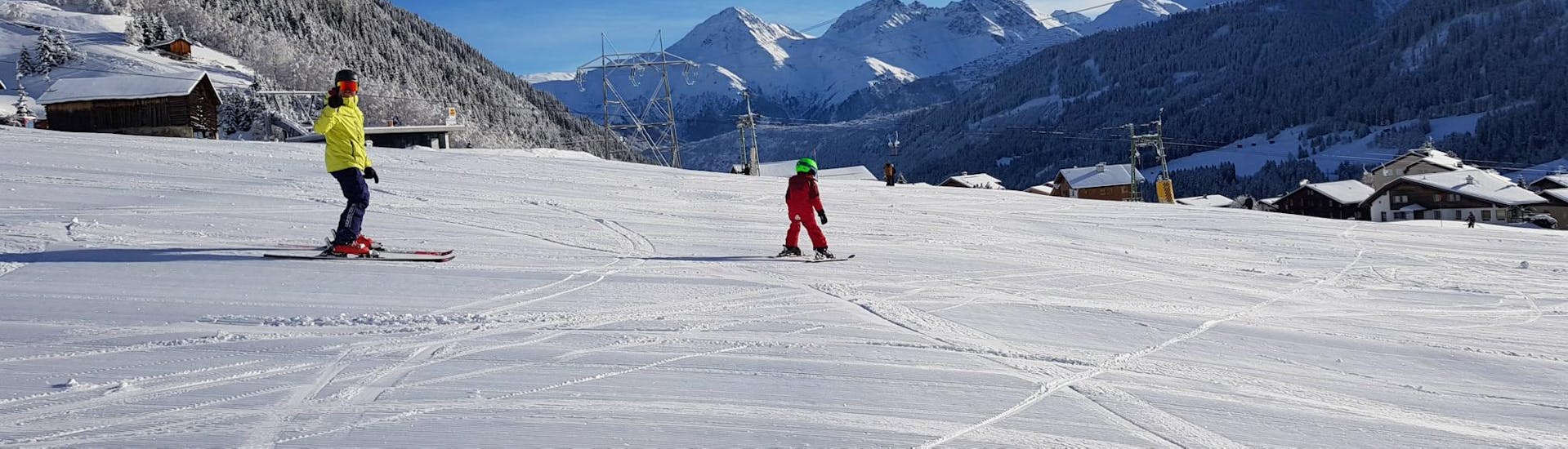 Ein Privatlehrer betreut im Angebot Privater Kinder Skikurs (ab 3 Jahren) - All Levels der Skischule Monntains einen jungen Skifahrer.