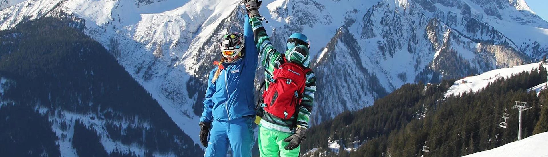 Beim privaten Snowboardkurs der Skischule Habeler Mayrhofen klatscht eine Snowboardlehrerin mit ihrem Schüler ab.