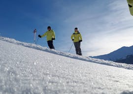 Im Angebot Privater Skikurs für Erwachsene - Alle Levels hören die Teilnehmer aufmerksam dem Skilehrer zu.