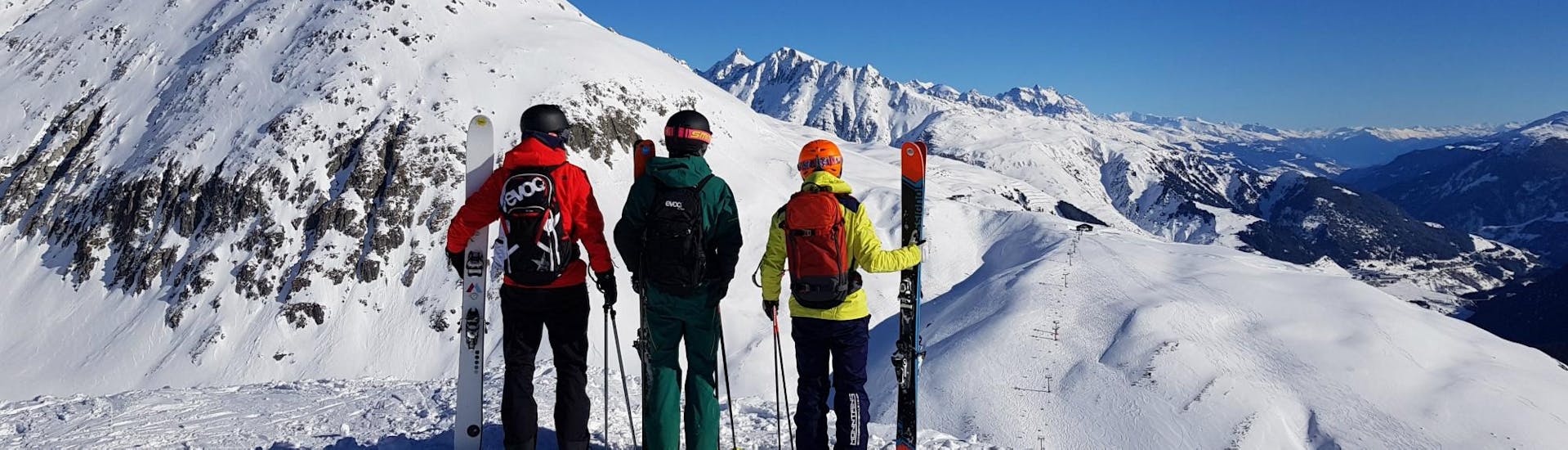 An instructor is showing the participants of the Private Off-Piste Skiing Lessons - All Levels with Skischule Monntains the best freeride runs of Sedrun and Disentis.