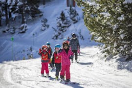 Een groep kinderen leert skiën tijdens een kinderskiles voor alle niveaus met Escuela Española de Esqui y Snowboard de Cerler.
