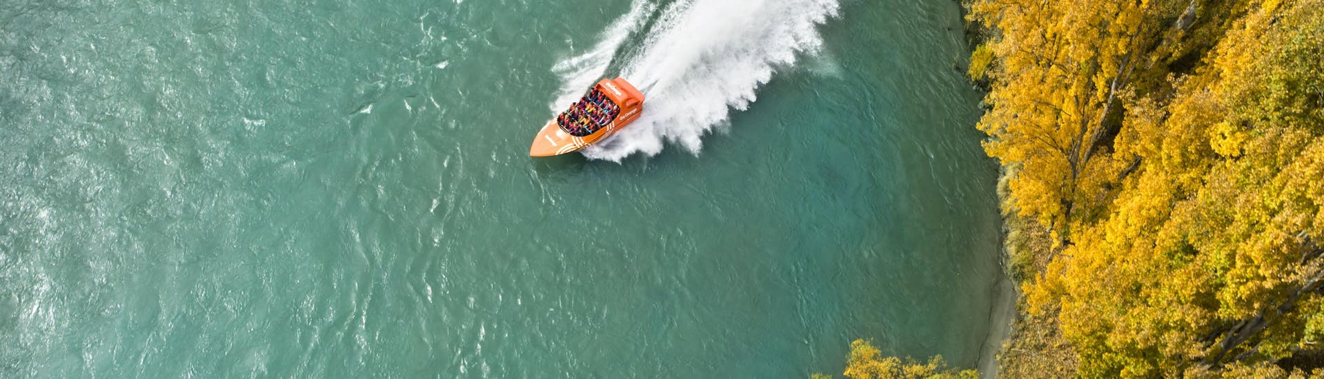A jet boat is making a 360° spi during Jet Boat Tour from Queenstown organized by Go Orange