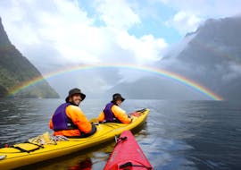 A full rainbow appears on the horizon during Kayak Tour in Milford Sound Fiord organized by Go Orange