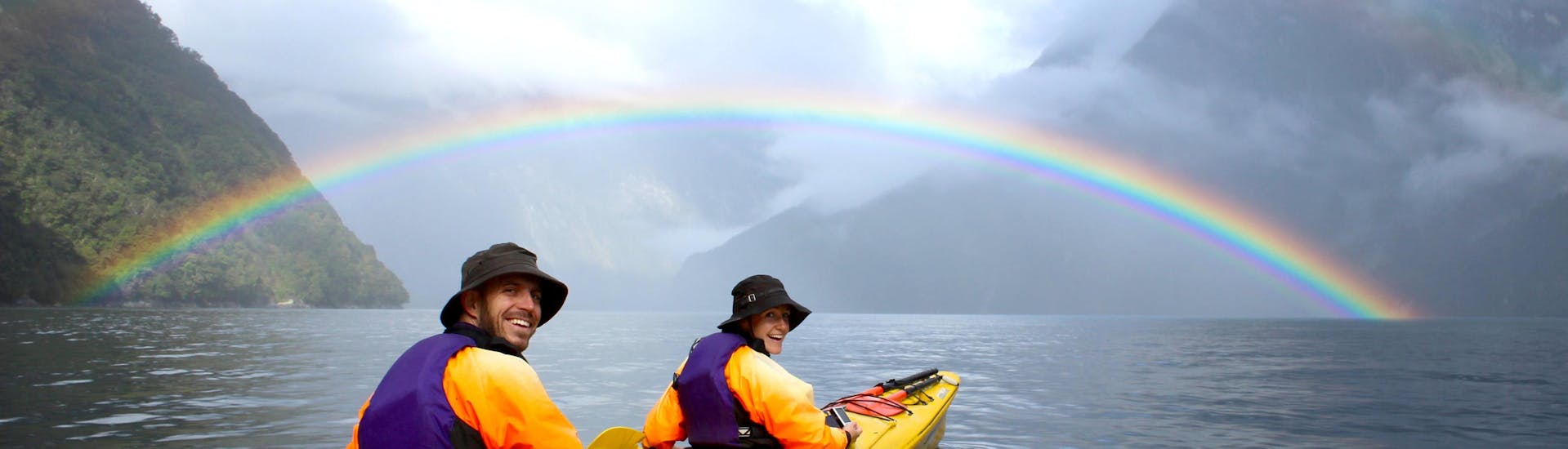 A full rainbow appears on the horizon during Kayak Tour in Milford Sound Fiord organized by Go Orange