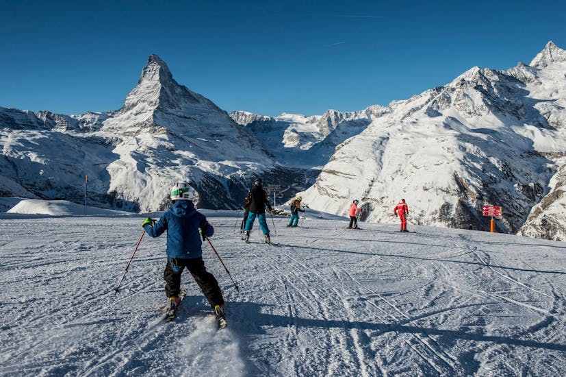 Die Teilnehmer im Kinder Skikurs (6–14 Jahre) - Fortgeschritten von Zermatters folgen ihrem Skilehrer auf den Pisten des Matterhorn Ski Paradise.