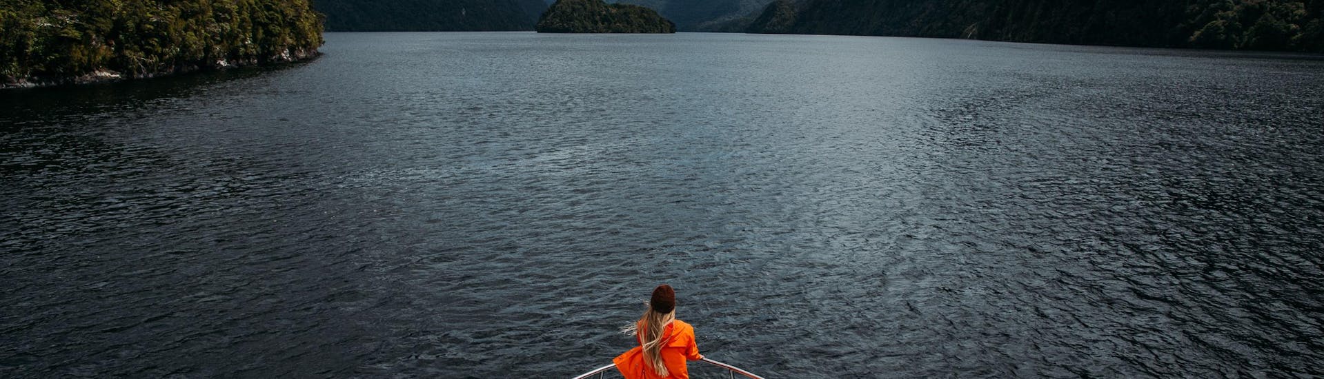 A participant of the Doubtful Sound Cruise organized by Go Orange is enjoying views from Tasman Explorer vessel