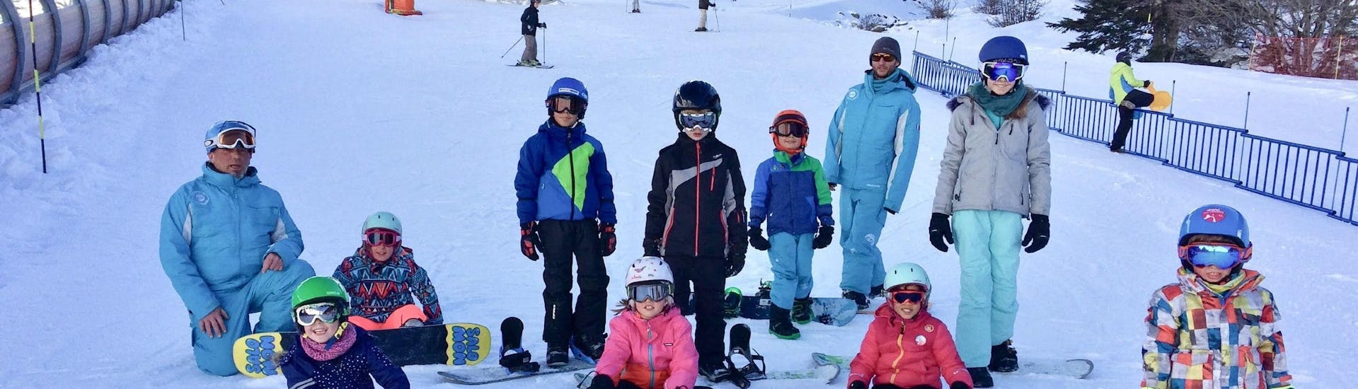 Los snowboarders están sentados en la nieve listos para empezar sus clases de snowboard para niños & adultos - Todos los niveles con la escuela de esquí ESI Ecoloski Barèges.