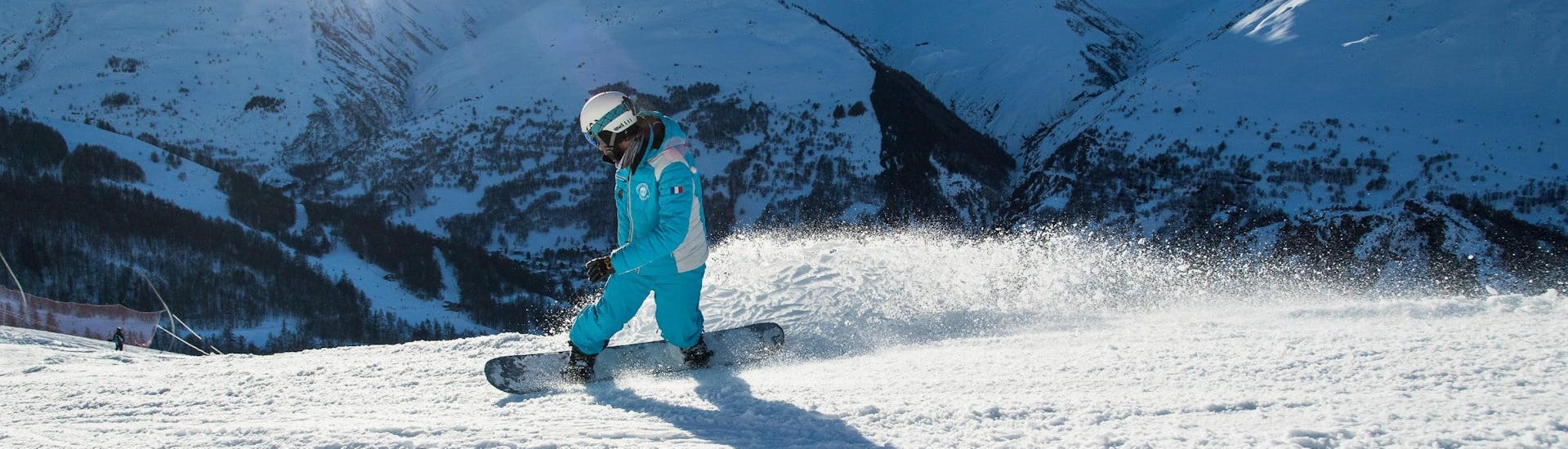 Un instructor de snowboard de la escuela de esquí ESI Ecoloski Barèges está mostrando sus habilidades de snowboard durante las clases particulares de snowboard - Temporada baja.