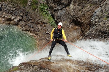 During the Extreme Canyoning tour in Allgäu with canyoning erleben, a participant is roping down over a waterfall.