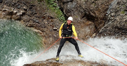 Extreem canyoning in de Allgäu voor sportieve canyoningers met canyoning erleben Allgäu Tijdens de Extreme Canyoning tour in Allgäu met canyoning erleben, daalt een deelnemer in een touw af over een waterval.
