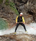 During the Extreme Canyoning tour in Allgäu with canyoning erleben, a participant is roping down over a waterfall.