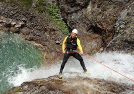 Bei der Extrem Canyoning Tour im Allgäu mit canyoning erleben seilt sich ein Teilnehmer über einen Wasserfall ab.