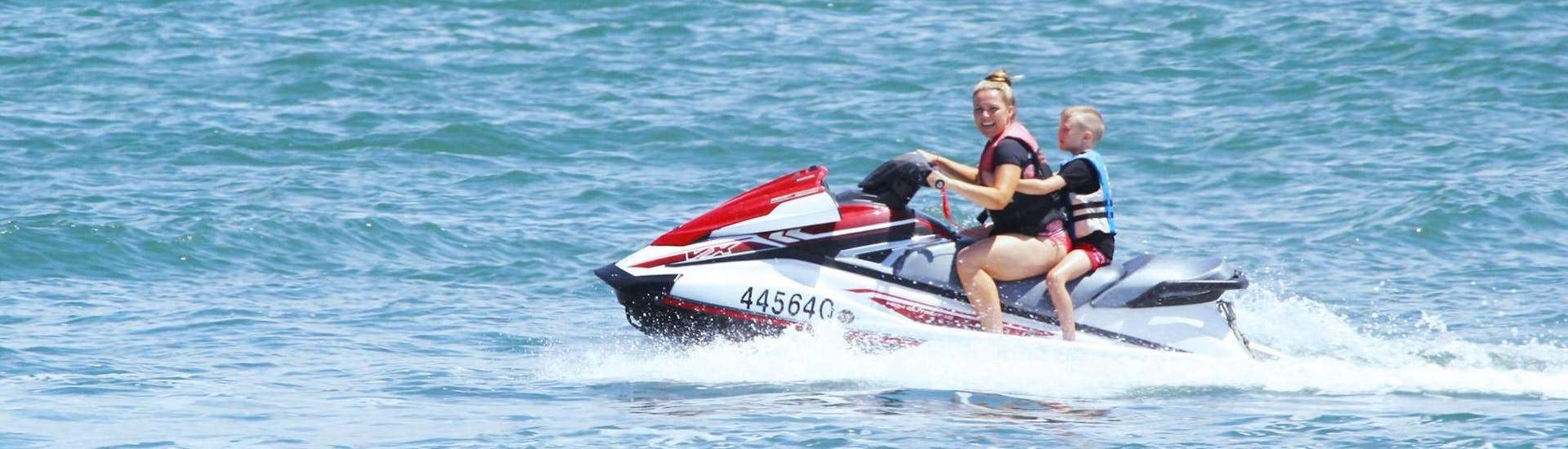 Under a supervision of an experienced instructor from Gold Coast Watersports, a mother is enjoying a jet ski ride with her son during the Jet Ski in Gold Coast - Hire.