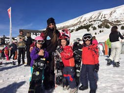 Snowboarders se abrazan durante sus clases particulares de snowboard para niños y adultos de la Escuela Esquí y Snowboard Valle de Benás.