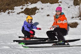 A kid during the Kids Ski Lessons (3-4 y.) - All Levels at the ski school Scuola Italiana di Sci Civetta help children to get started on their skis.
