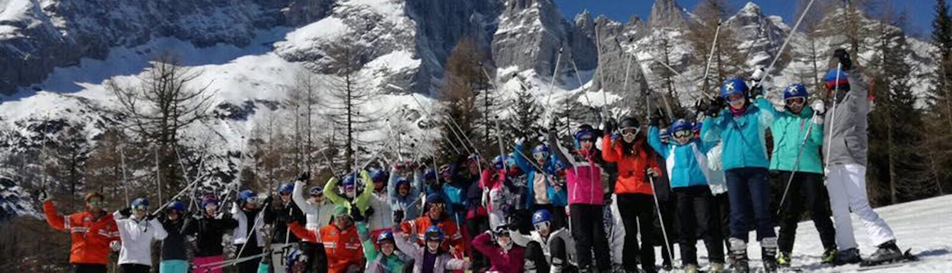 Der Kids Ski Lessons (from 9 y.) - Full Day - Advanced ist vorbei und die Teilnehmer des Abschlussrennens stehen auf dem Podium, der Lehrer der Skischule Scuola Italiana di Sci Civetta feiert mit ihnen.