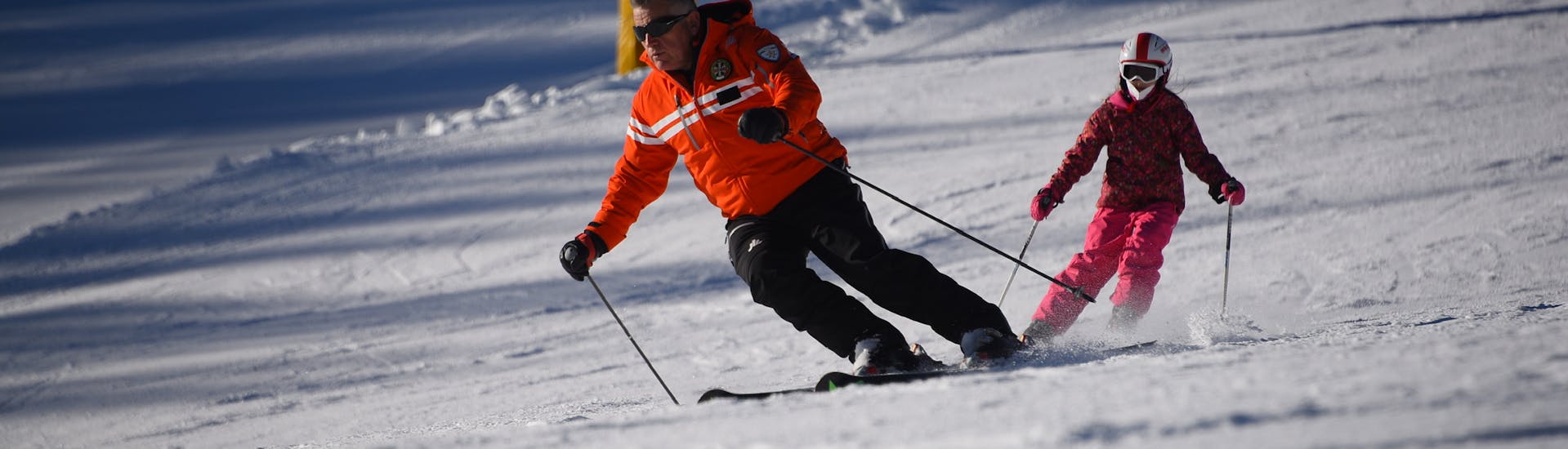 Un bambino e il suo istruttore durante delle Lezioni private di sci per bambini per tutti i livelli con Scuola Sci Civetta - Val di Zoldo Pecol.