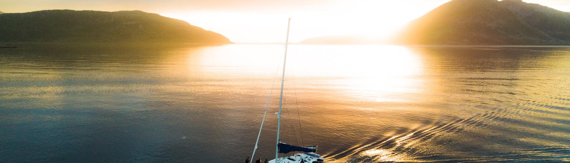 Our beautiful catamaran bathing in the midnight sunlight during the Arctic Midnight Sunset Boat Tour in Tromsø with Pukka Travels.
