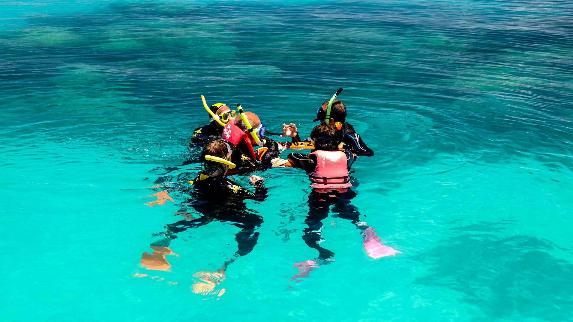 During the Snorkeling excursion in the Great Barrier Reef from Cairns, a guide from Ocean Spirit Cruises is briefing a group of snorkelers.