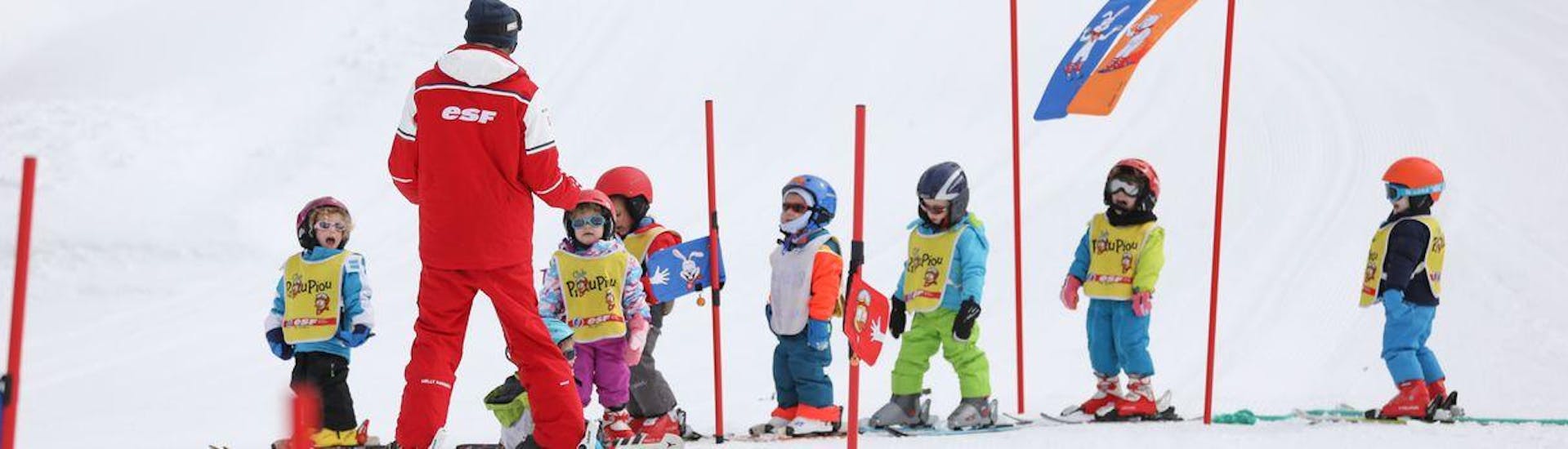 Des enfants se tiennent à la queue leu leu apprenant à trouver leur équilibre sur les skis pendant leur Cours de ski Enfants "Piou-Pou" (3-5 ans) - Février - Matin avec l'école de ski ESF du Dévoluy.
