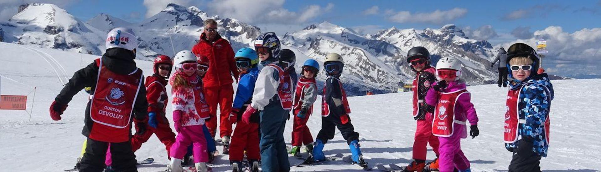 Des enfants se tiennent au sommet de la piste attendant de commencer leur Cours de ski pour Enfants "Ourson" (5-12 ans) avec l'école de ski ESF du Dévoluy.