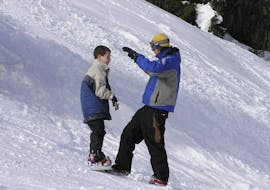 Foto de un instructor y un participante durante las Clases de Snowboard para Niños "Learn 2 Ride" para Principiantes con la Escuela de Snowboard SMT Mayrhofen.
