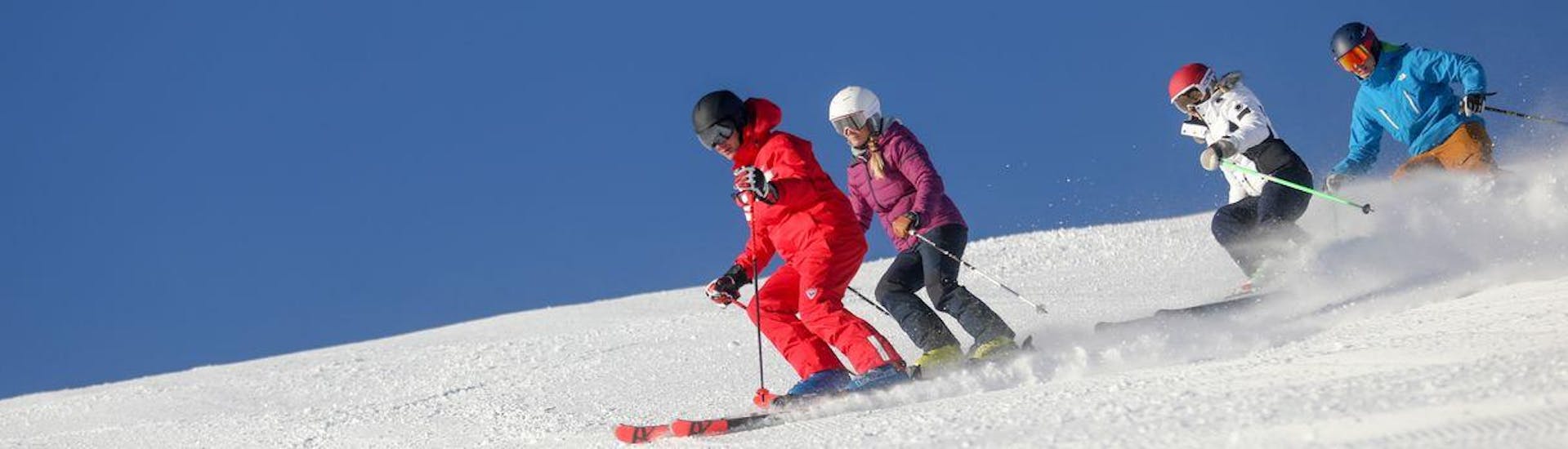 Des skieurs suivent leur moniteur de ski de l'école de ski ESF du Dévoluy le long d'une pente enneigée pendant leur Cours de ski pour Adultes - Tous niveaux.