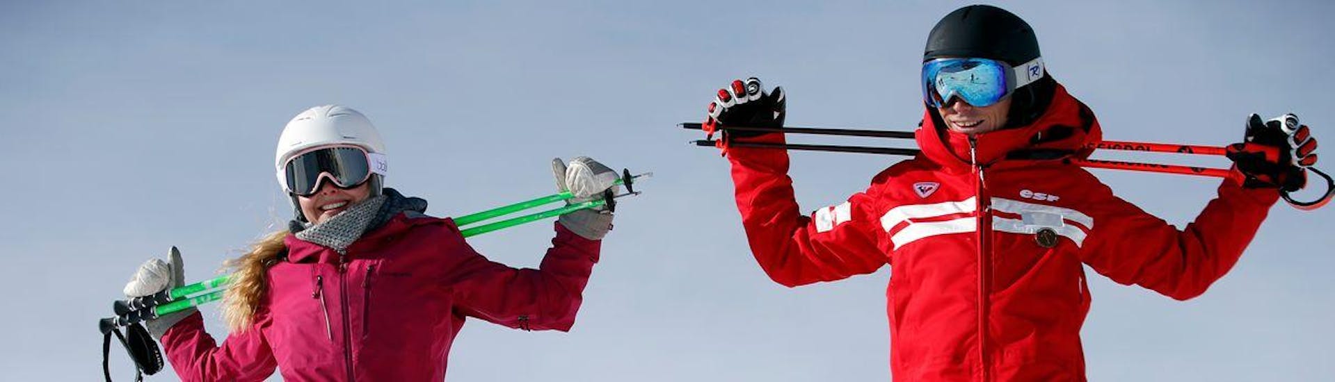 Avec ses bâtons de ski sur les épaules, un skieur est heureux de participer à son Cours particulier de ski pour Enfants - Tous âges avec son moniteur de ski de l'école de ski ESF du Dévoluy.