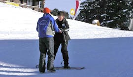 Bild eines Lehrers mit seinem Schüler während des Snowboard Privatunterrichts für Kinder & Erwachsene aller Könnerstufen mit der Snowboardschule SMT Mayrhofen.