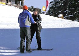 Bild eines Lehrers mit seinem Schüler während des Snowboard Privatunterrichts für Kinder & Erwachsene aller Könnerstufen mit der Snowboardschule SMT Mayrhofen.
