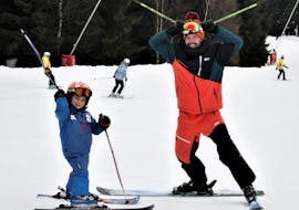 During the Private Ski Lessons for Kids - All Levels, a small kid is learning how to ski under the supervision of an experienced ski instructor from the ski school SnowMonkey in Špindlerův Mlýn.