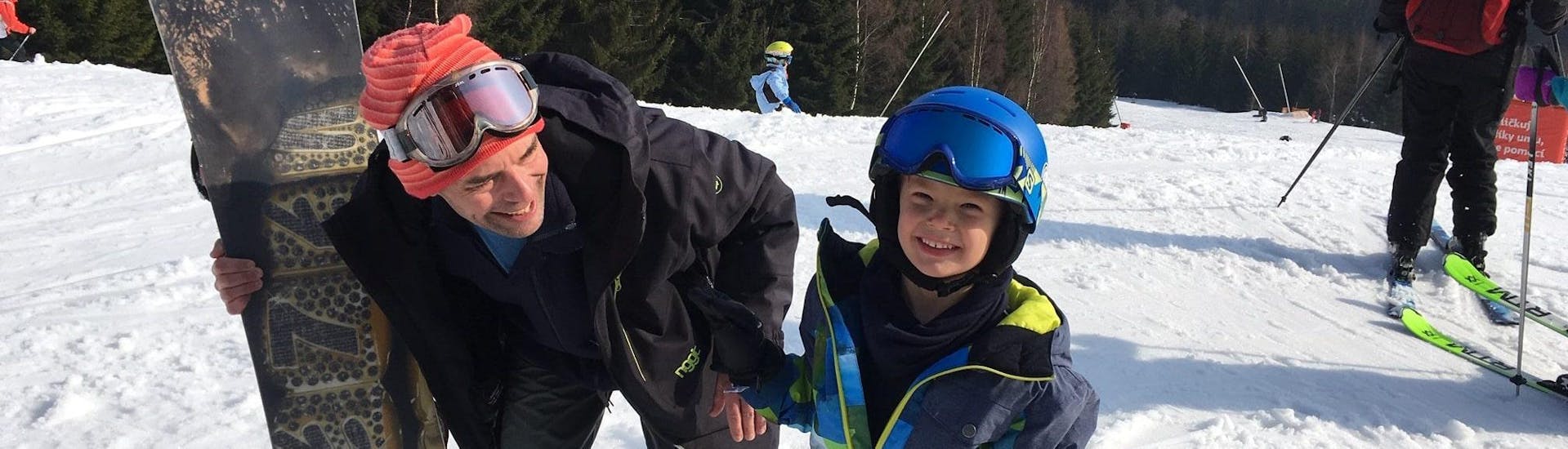 A small boy is enjoying the Private Ski Lessons for Kids - All Levels with his ski instructor from the ski school SnowMonkey.