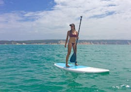 A young woman is standing on a stand up paddle board at Double Island Point during the SUP Noosa wildlife day trip with Epic Ocean Adventures Noosa.