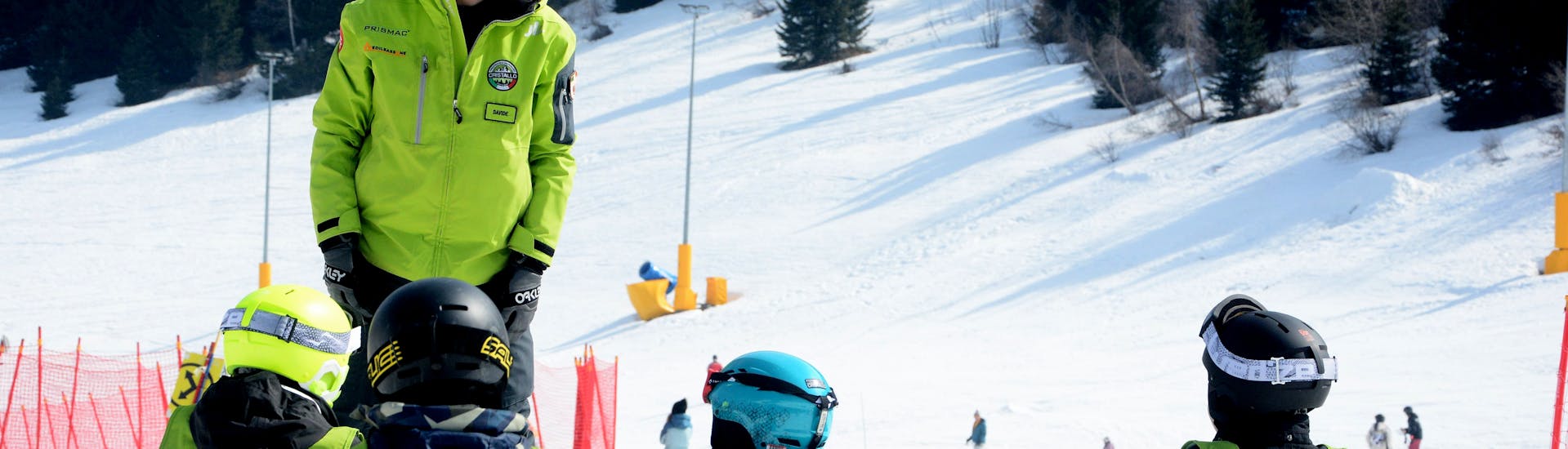 Un istruttore parla con i bambini durante una delle Lezioni private di snowboard - Tutte le età e livelli organizzate dai Maestri di Sci Cristallo - Monte Bondone nel comprensorio sciistico del Monte Bondone.