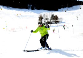 Ein Skilehrer und ein Teilnehmer im Skikurs für Erwachsene - Alle Levels der Maestri di Sci Cristallo - Monte Bondone lächeln im Skigebiet Monte Bondone in die Kamera.