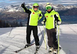 A ski instructor smiling at the camera with a participant of the Ski Lessons for Adults - All Levels organized by Maestri di Sci Cristallo - Monte Bondone in the ski resort of Monte Bondone.