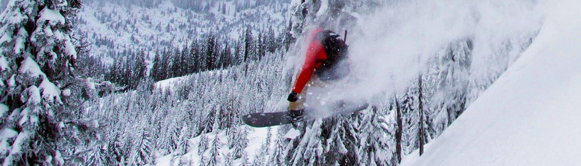 Een snowboarder maakt een sprong in de verse poedersneeuw tijdens zijn Snowboardlessen (vanaf 8 jaar) - Alle niveaus bij de skischool Moonshot La Bresse.