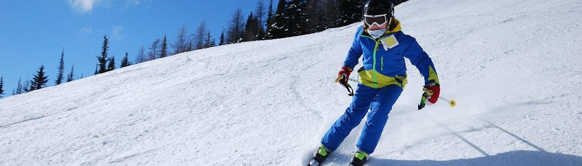 A skier is skiing down a slope with confidence during their Private Ski Lessons for Kids - Holidays with the ski school Moonshot La Bresse.