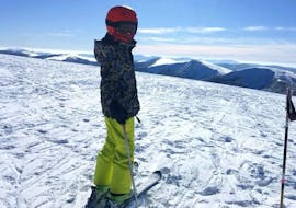 Un skieur se tient au sommet d'une piste attendant de commencer son Cours particulier de ski pour Enfants - Vacances avec l'école de ski Moonshot La Bresse.