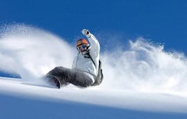 Un snowboardeur dévale une pente en toute confiance lors de son Cours particulier de snowboard (dès 6 ans) - Vacances avec l'école de ski Moonshot La Bresse.