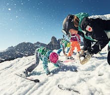 Kinder spielen mit ihrem Skilehrer in La Villa während ihrem Kinder-Skikurse für Anfänger.