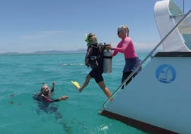 The Reef Daytripper Cairns is helping a first-time diver to get into the water during the Great Barrier Reef Diving Trip - Introductory Dive offer.