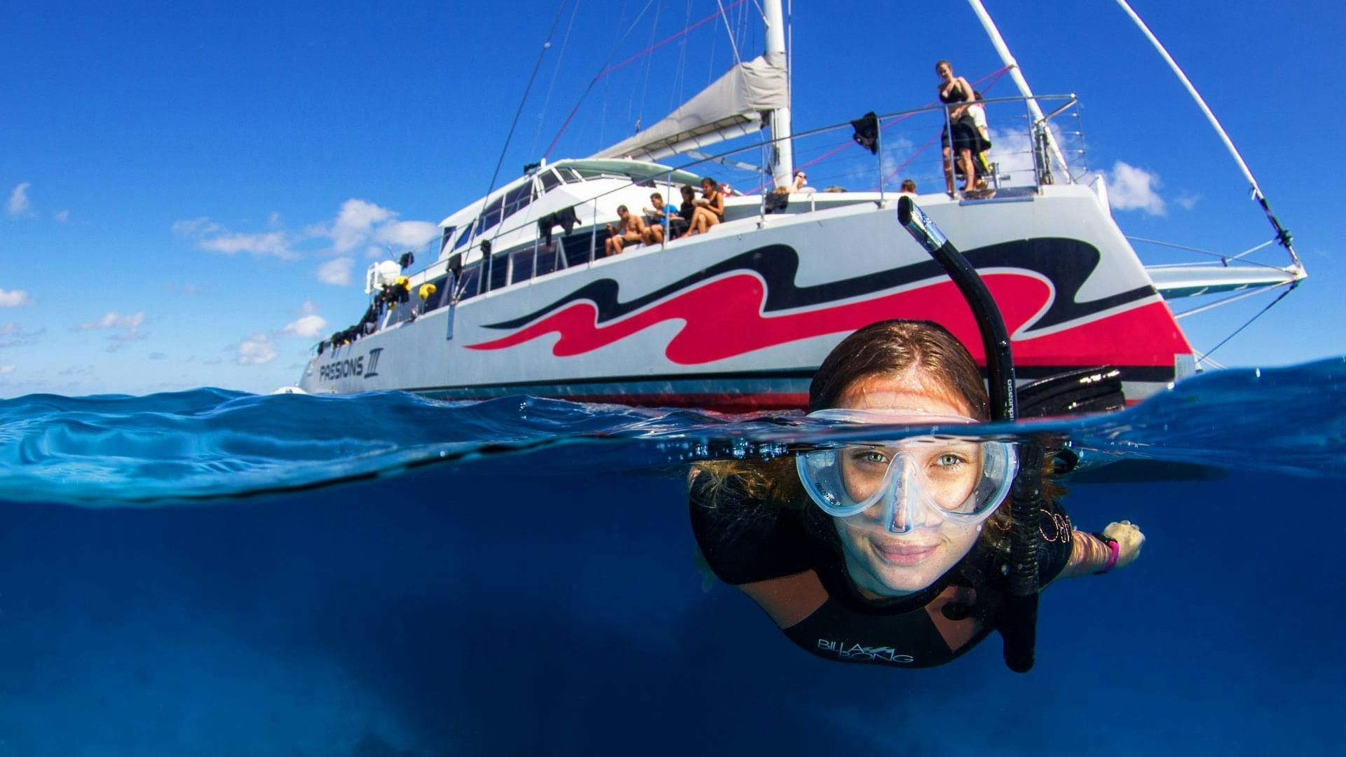 A father is enjoying a guided snorkeling with his son during the Boat Tour with Snorkeling on the Great Barrier Reef organised by Passions of Paradise.