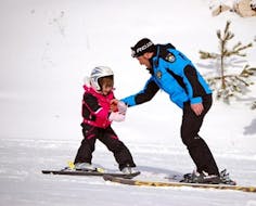 Un piccolo sciatore sta imparando a sciare con un maestro privato durante una delle Lezioni private di sci per bambini - Principianti organizzate dalla Scuola di Sci Tre Nevi Ovindoli nel comprensorio sciistico di Ovindoli sul Monte Magnola.