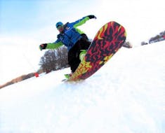 Un maestro di snowboard privato si sta divertendo sulla tavola durante una delle Lezioni private di snowboard - Principianti organizzate dalla Scuola di Sci Tre Nevi Ovindoli nel comprensorio sciistico di Ovindoli sul Monte Magnola.