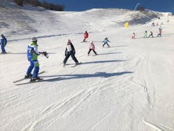 A group of young skiers is learning how to ski during one of the Kids Ski Lessons (4-14 y.) - Beginner organized by the ski school Scuola di Sci Tre Nevi Ovindoli in the ski resort of Ovindoli on the Monte Magnola.